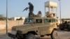 FILE - A soldier serving in the African Union Mission in Somalia (AMISOM) prepares to jump off a military vehicle near the scene of a suicide bombing targeting an AMISOM convoy in Mogadishu, Nov. 11, 2021. 