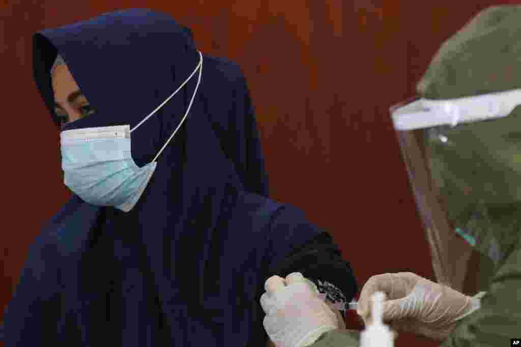 دریافت واکسن کرونا توسط یک زن مسلمان در یک مرکز واکسیناسیون در جاکارتا، اندونزی