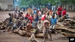 A group of Burundian refugee children sit on a pile of wood, at the Gashora refugee camp in the Bugesera district of Rwanda, April 21, 2015. Officials in Burundi say refugees in neighboring Rwanda are being recruited to fight against the Burundian government.