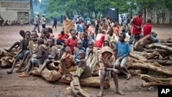 Un groupe d'enfants réfugiés burundais assis sur un tas de bois, dans le camp de réfugiés de Gashora dans le district de Bugesera, au Rwanda, 21 avril 2015. (AP Photo / Edmund Kagire)