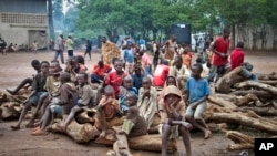 FILE - A group of Burundian refugee children sit on a pile of wood, at the Gashora refugee camp in the Bugesera district of Rwanda, April 21, 2015.