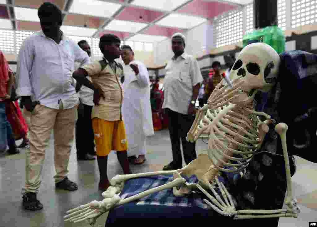 Bystanders look a replica of a human skeleton smoking a cigarette during an awareness rally marking &#39;World No-Tobacco Day,&#39; in Chennai, India.