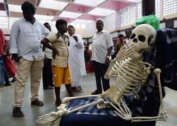 FILE - Bystanders look a replica of human skeleton smoking cigarette during an awareness rally on occasion of the "World No-Tobacco Day," in Chennai, India, May 31, 2019.