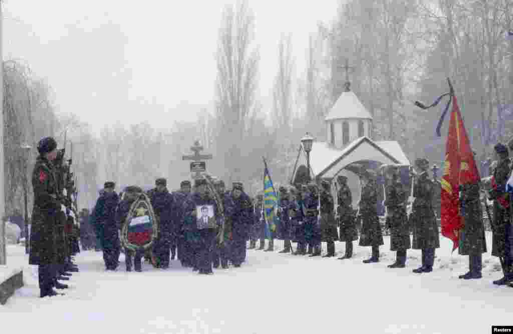 Honor guards stand at attention during the funeral ceremony of Oleg Peshkov, a Russian pilot of the downed SU-24 jet, at a cemetery in Lipetsk, Russia. Peshkov was awarded the Hero of Russia award posthumously.