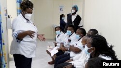 FILE - A health worker talks to colleagues as they prepare to receive a coronavirus vaccine at the Kenyatta National Hospital in Nairobi, Kenya, March 5, 2021. 