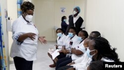 FILE - A health worker talks to colleagues as they prepare to receive a coronavirus vaccine at the Kenyatta National Hospital in Nairobi, Kenya, March 5, 2021. 