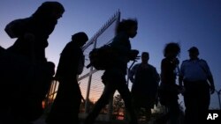 FILE - Migrants from Syria walk into a refugee camp in Kokkinotrimithia village outside the capital Nicosia, Cyprus.