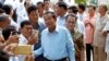 Cambodian Prime Minister Hun Sen, center, of ruling Cambodian People's Party pose for a selfie with his party supporters after a voting in the Senate election at Takhmau polling station in Kandal province, southeast of Phnom Penh, Cambodia, Sunday, Feb. 25, 2018. Cambodia's ruling party is assured of a sweeping victory in the election of a new Senate after the only real opposition to it was eliminated. (AP Photo/Heng Sinith)