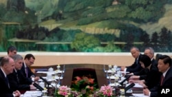 U.S. National Security Adviser Tom Donilon, left, and Chinese President Xi Jinping, right, attend their meeting at the Great Hall of the People in Beijing, May 27, 2013. 