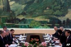 U.S. National Security Adviser Tom Donilon, left, and Chinese President Xi Jinping, right, during their meeting in Beijing, May 27, 2013.