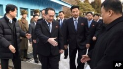 Head of North Korean delegation Ri Son Gwon, center, is greeted by South Korean officials after he crosses the border line to attend their meeting at Panmunjom in the Demilitarized Zone in Paju, South Korea, Jan. 9, 2018. (Korea Pool via AP)