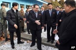 Head of North Korean delegation Ri Son Gwon, center, is greeted by South Korean officials after he crosses the border line to attend their meeting at Panmunjom in the Demilitarized Zone in Paju, South Korea, Jan. 9, 2018.