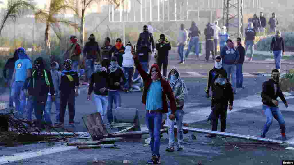 Israeli Arab youths clash with Israeli police at the entrance to the town of Kfar Kanna, in northern Israel, Nov. 8, 2014. 