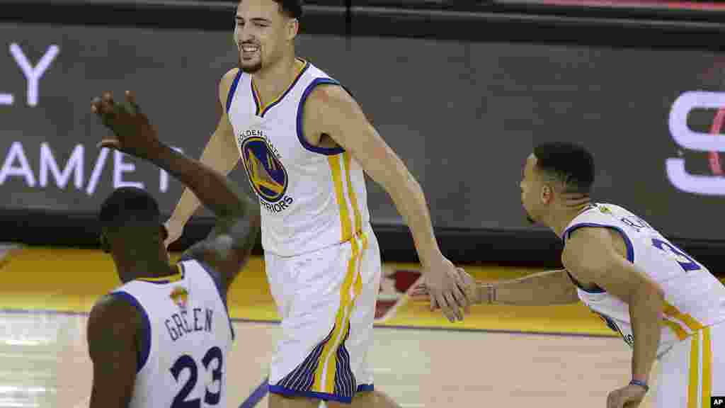 Le joueur de Golden State Warriors Klay Thompson, centre, célèbre avec avec Draymond Green (23) et Stephen Curry au cours de la deuxième moitié du match 1 de la finale NBA de basket-ball contre les Cavaliers de Cleveland à Oakland, en Californie, jeudi 2 Juin, 2016.