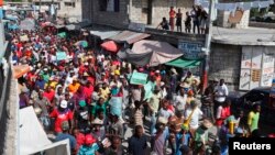 Demonstrators march through the streets during an anti-government protest in Port-au-Prince, December 5, 2014.