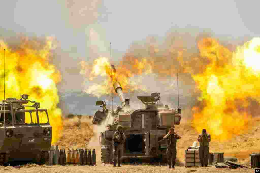 An Israeli artillery unit fires toward targets in Gaza Strip, at the Israeli-Gaza border.