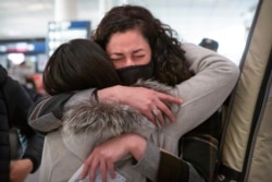 Wall Street Journal reporters Julie Wernau embraces a colleague before her departure at Beijing Capital International Airport in Beijing, March 28, 2020.