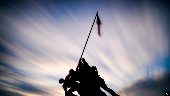 El sol se pone detrás del Monumento de Guerra del Cuerpo de Marines de los EE.UU. en Arlington, Virginia.