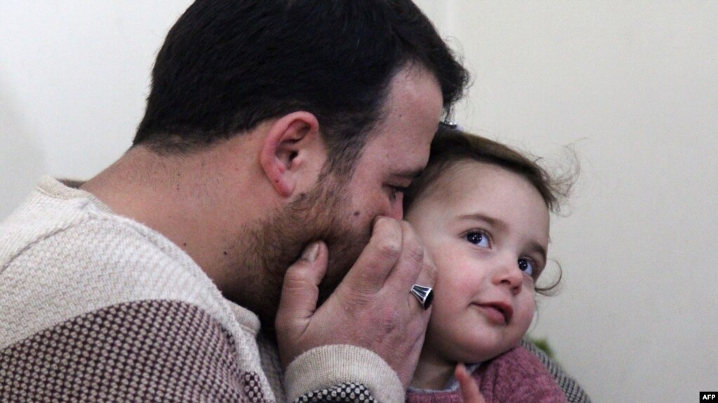 Syrian father Abdullah al-Mohammed whispers on the ear of his three-year-old daughter Salwa at their home in Sarmada, on February 19, 2020.