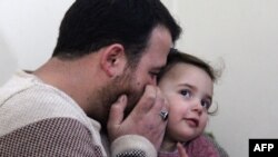 Syrian father Abdullah al-Mohammed whispers on the ear of his three-year-old daughter Salwa at their home in Sarmada, on February 19, 2020.