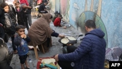 FILE — Displaced Palestinians taking shelter in a UN school in Bureij in the central Gaza Strip, make bread on November 21, 2023, amid the ongoing battles between Israel and the Palestinian militant group Hamas.