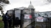 Anggota kepolisian Gedung Capitol berdiri di dekat gerbang masuk gedung tersebut yang dipagari, di Washington, pada 2 Januari 2025. (Foto: AFP/Roberto Schmidt)