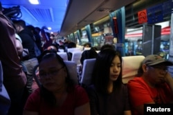 Janice Sarad, 22, who works for a bank, rides a crowded bus going to work in Cubao, Quezon City, Metro Manila, Philippines, Nov. 26, 2018.