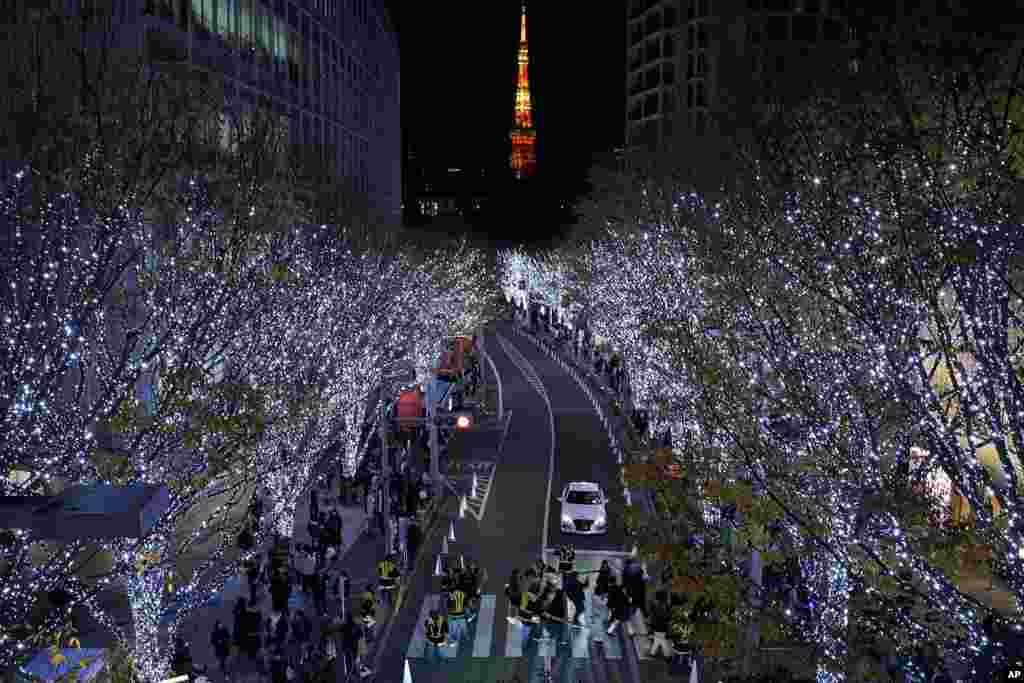 People walk through the annual year end illumination in Roppongi district in Tokyo, Japan.