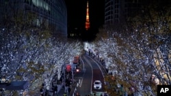 People walk through the annual year end illumination in Roppongi district in Tokyo, Japan.