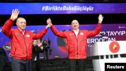 فضانورد ترکیه‌ای در کنار رجب طیب اردوغان، رئیس جمهوری ترکیه، در نمایشگاه فضایی «تکنوفست» در شهر استانبول (سمت چپ)