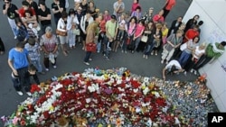 People place candles, toys and flowers as they observe a day of mourning for victims of a cruise vessel that sank July 10 at the port of Kazan, Russia, July 12, 2011 (file photo) (AP Photo/Misha Japaridze)