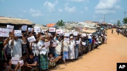 Rohingya refugees holding placards await the arrival of a U.N. Security Council team at the Kutupalong Rohingya refugee camp in Kutupalong, Bangladesh, April 29, 2018. A U.N. Security Council team visiting Bangladesh promised Sunday to work hard to resolv