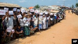 Para pengungsi Muslim Rohingya membawa plakat, menunggu kedatangan tim DK PBB di kamp pengungsi Kutupalong, Bangladesh, 29 April 2018.