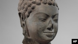 FILE - This December 2005 photo shows a 7th century sculpture titled "Head of Buddha" at the Metropolitan Museum of Art in New York. The sculpture is one of 16 pieces of artwork that the museum said it will return to Cambodia and Thailand.