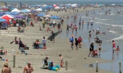 People are seen gathered on the beach for Memorial Day weekend in Port Aransas, Texas, May 23, 2020.