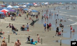 People are seen gathered on the beach for Memorial Day weekend in Port Aransas, Texas, May 23, 2020.