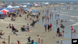 People gather on the beach for the Memorial Day weekend in Port Aransas, Texas, May 23, 2020. Beachgoers are being urged to practice social distancing to guard against COVID-19.