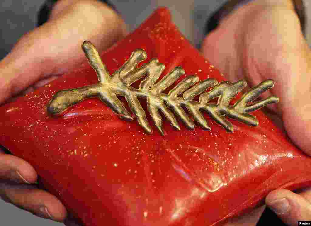 French chocolate maker Jean-Patrice Paci holds a Palme d&#39;Or chocolate creation in his shop during the 67th Cannes Film Festival. The Palme d&#39;Or, the festival&#39;s top prize, will be awarded Saturday May 24, 2014.