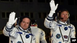 FILE - Russian cosmonaut Gennady Padalka, right, and U.S. astronaut Scott Kelly, crew members of the mission to the International Space Station, ISS, wave prior to the launch of Soyuz-FG rocket at the Russian-leased Baikonur cosmodrome, Kazakhstan, March 27, 2015.