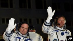 U.S. astronaut Scott Kelly, left, and Russian cosmonaut Gennady Padalka, crew members of the mission to the International Space Station, ISS, wave prior to the launch of Soyuz-FG rocket at the Russian-leased Baikonur cosmodrome, Kazakhstan, March 27, 201