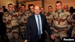 French Defense Minister Jean-Yves Le Drian (C) poses with French soldiers as they prepare to depart for Mali during a visit at the military base of Miramas, southern France, January 25, 2013.