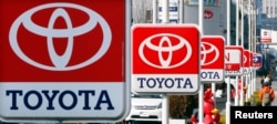FILE - Toyota Motor Corp. signboards are displayed at a dealer's shop in Yokohama, south of Tokyo.