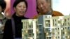 南京的市民在房地产交易会上观看公寓楼的模型
