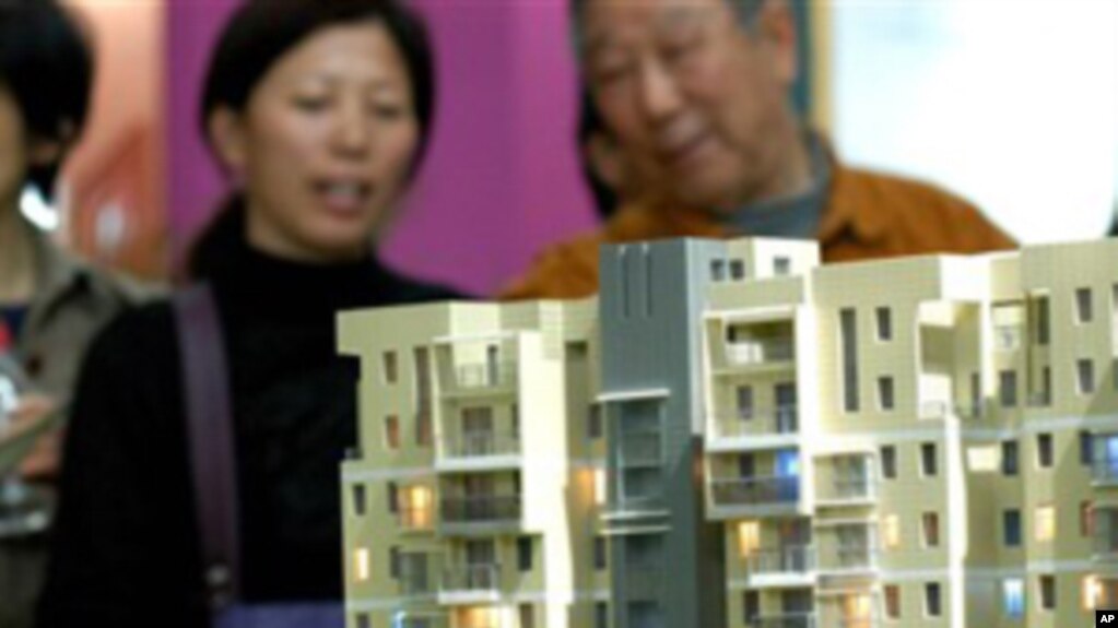 南京的市民在房地产交易会上观看公寓楼的模型(photo:VOA)