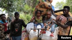 Para migran Kongo yang didepotasi oleh Angola beristirahat di kota Tshikapa, Kasai, Kongo. 