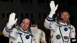 Phi hành gia Hoa Kỳ Scott Kelly (trái) và phi hành gia Nga Gennady Padalka vẫy chào trước khi phi thuyền được phóng đi, 27/3/15