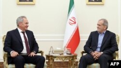 A handout photo provided by the Iranian presidency shows President Masoud Pezeshkian, right, meeting with Russia's Security Council Secretary Sergei Shoigu in Tehran, Sept. 17, 2024.