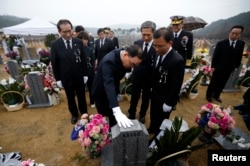 FILE - South Korea's then-Prime Minister Jung Hong-won, center, pays respects at the grave of a sailor -- killed in the 2010 sinking of the Cheonan -- at National Cemetery in Daejeon, March 26, 2014.