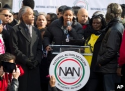 The Reverend Al Sharpton, left, listens as Eric Garner's widow Esaw speaks during a demonstration at Freedom Plaza in Washington, Dec. 13, 2014.