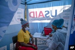 FILE - Nurse Nomautanda Siduna talks to a patient who is HIV-positive inside a gazebo used as a mobile clinic in Ngodwana, South Africa, July 2, 2020.